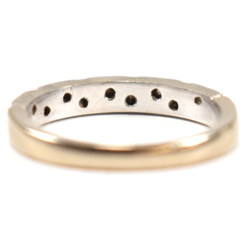 171 - A hallmarked 18ct white gold and diamond half eternity ring. The ring having a single row of nine il... 