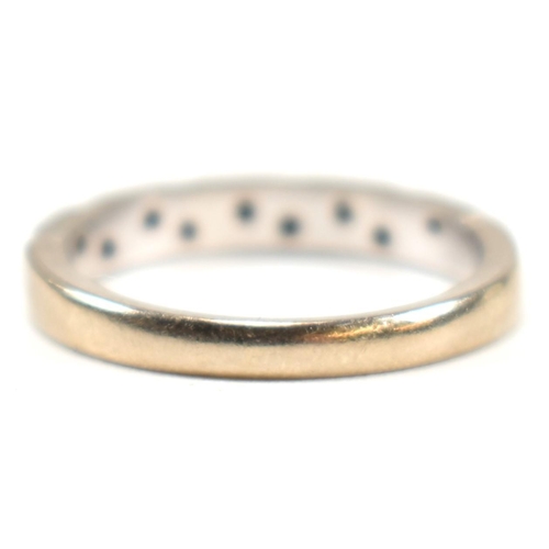 171 - A hallmarked 18ct white gold and diamond half eternity ring. The ring having a single row of nine il... 