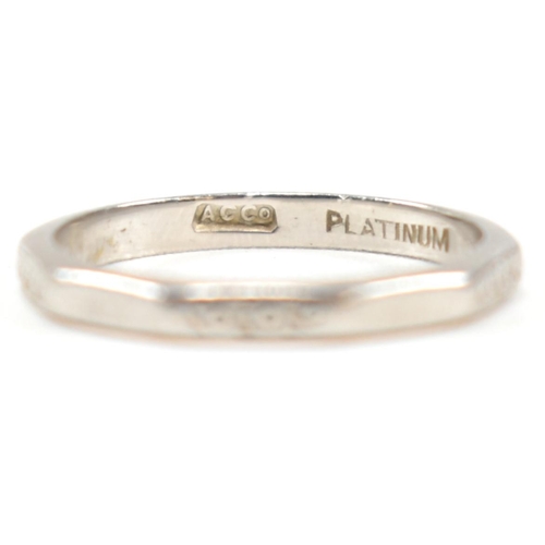 175 - A platinum faceted band ring. The ring having an etched design to every other facet, with the others... 