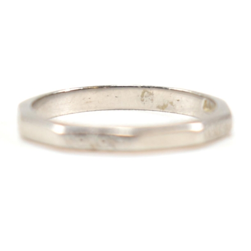 175 - A platinum faceted band ring. The ring having an etched design to every other facet, with the others... 