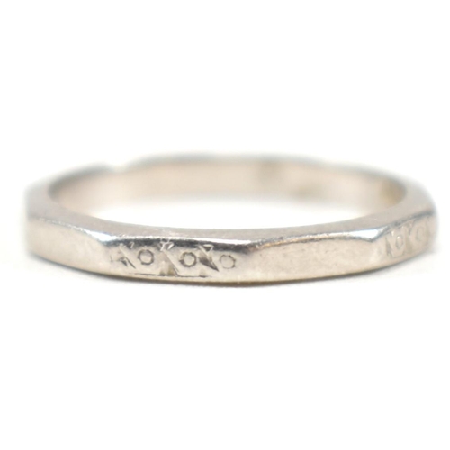 175 - A platinum faceted band ring. The ring having an etched design to every other facet, with the others... 