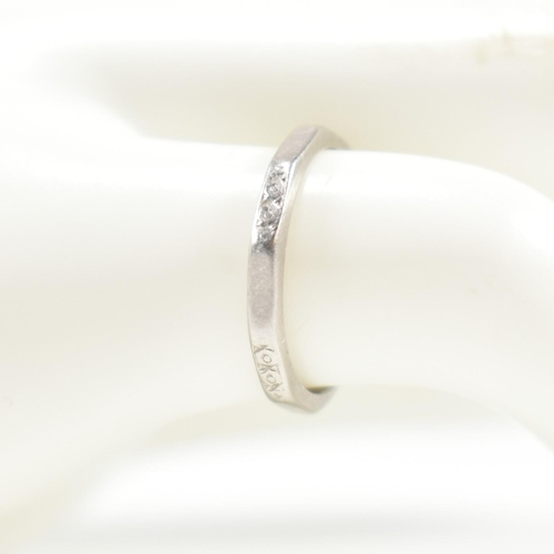 175 - A platinum faceted band ring. The ring having an etched design to every other facet, with the others... 