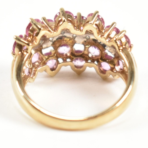 181 - A hallmarked 9ct gold, pink sapphire and diamond cluster ring. The ring set with sixteen round cut p... 