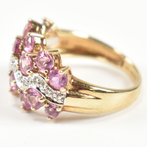 181 - A hallmarked 9ct gold, pink sapphire and diamond cluster ring. The ring set with sixteen round cut p... 