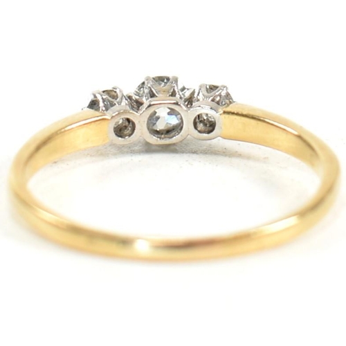 186 - An 18ct gold and diamond three stone ring. The ring having a central round brilliant cut diamond fla... 