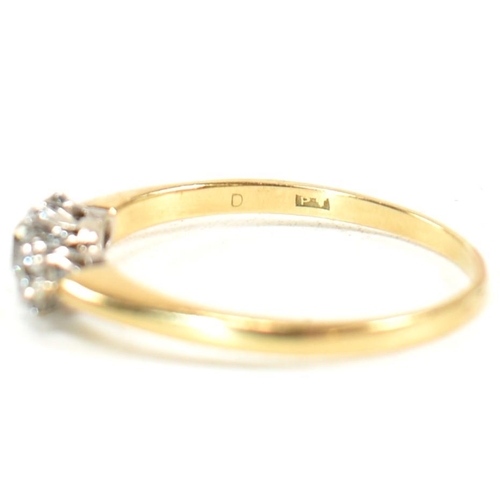 186 - An 18ct gold and diamond three stone ring. The ring having a central round brilliant cut diamond fla... 