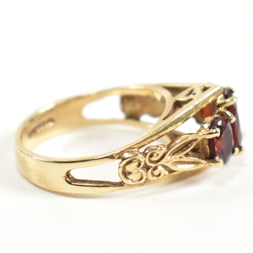 191 - A hallmarked 9ct gold and garnet trilogy ring. The ring set with three graduating four claw set oval... 