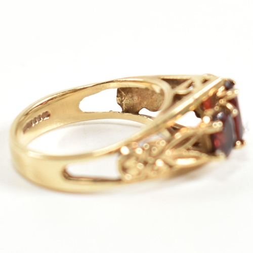 191 - A hallmarked 9ct gold and garnet trilogy ring. The ring set with three graduating four claw set oval... 