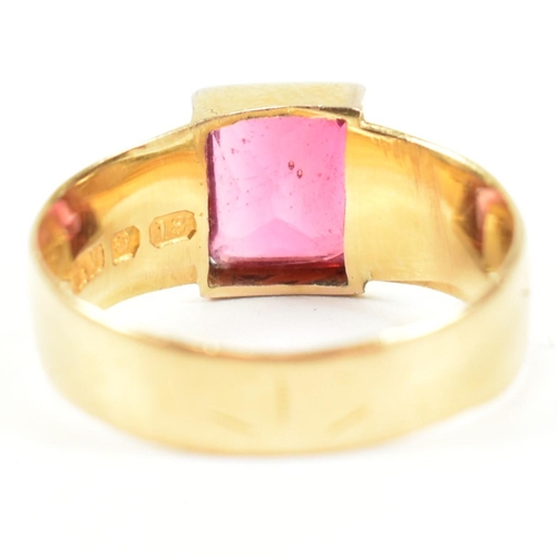 192 - A hallmarked 18ct gold and pink paste ring. The ring set with a single bezel set baguette cut pink p... 