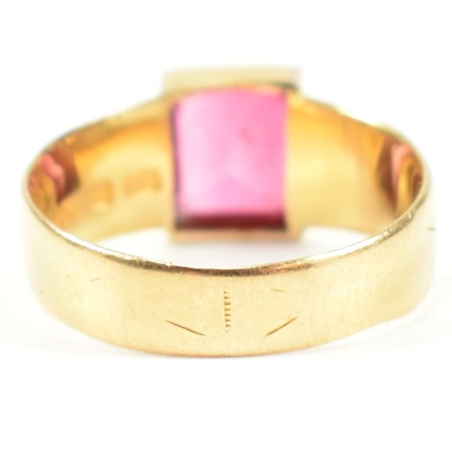 192 - A hallmarked 18ct gold and pink paste ring. The ring set with a single bezel set baguette cut pink p... 