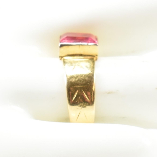 192 - A hallmarked 18ct gold and pink paste ring. The ring set with a single bezel set baguette cut pink p... 