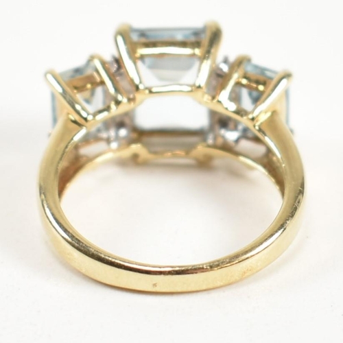 194 - A hallmarked 9ct gold aquamarine and diamond trilogy ring. The ring set with a central four claw set... 