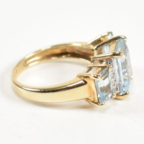 194 - A hallmarked 9ct gold aquamarine and diamond trilogy ring. The ring set with a central four claw set... 