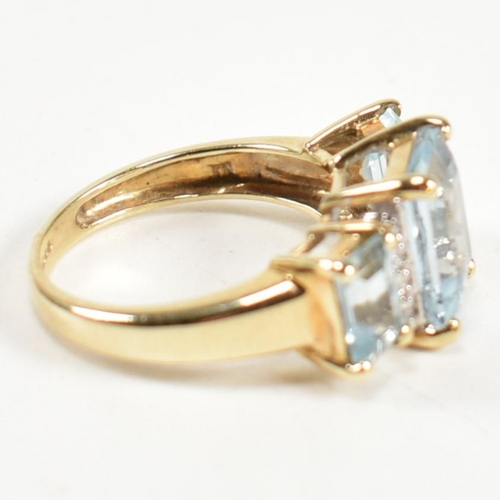 194 - A hallmarked 9ct gold aquamarine and diamond trilogy ring. The ring set with a central four claw set... 