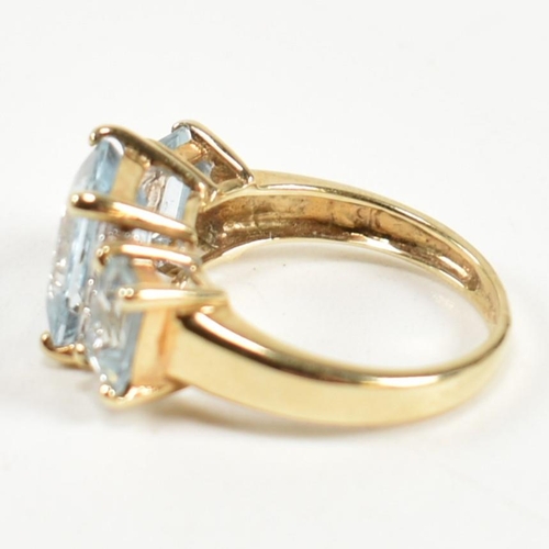 194 - A hallmarked 9ct gold aquamarine and diamond trilogy ring. The ring set with a central four claw set... 