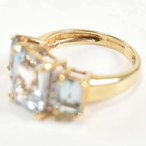 194 - A hallmarked 9ct gold aquamarine and diamond trilogy ring. The ring set with a central four claw set... 