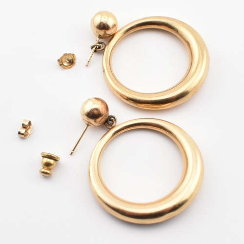 198 - A pair of 14ct gold hoop pendant earrings. The earrings having a gold hoop to straight posts. Marked... 