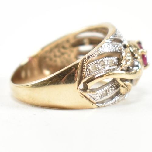 200 - A hallmarked 9ct gold, ruby and diamond ring. The ring having a central four claw set east-west oval... 