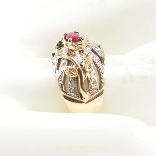 200 - A hallmarked 9ct gold, ruby and diamond ring. The ring having a central four claw set east-west oval... 