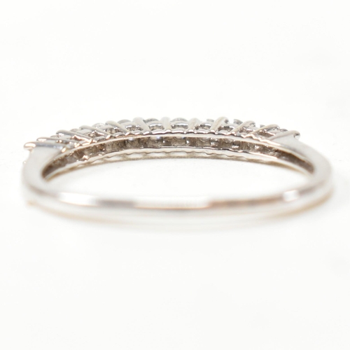 212 - A hallmarked 9ct white gold and diamond half hoop ring. The ring having a single row of eleven round... 