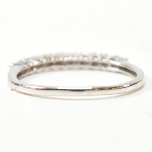 212 - A hallmarked 9ct white gold and diamond half hoop ring. The ring having a single row of eleven round... 