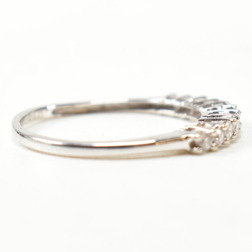 212 - A hallmarked 9ct white gold and diamond half hoop ring. The ring having a single row of eleven round... 