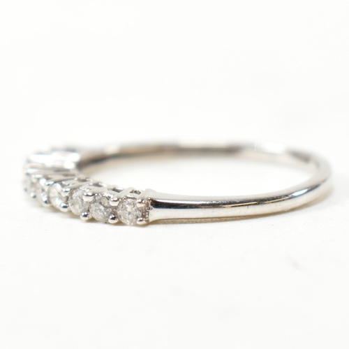 212 - A hallmarked 9ct white gold and diamond half hoop ring. The ring having a single row of eleven round... 