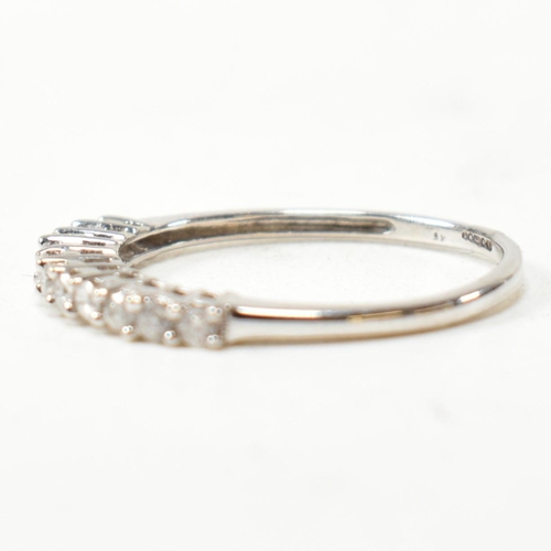 212 - A hallmarked 9ct white gold and diamond half hoop ring. The ring having a single row of eleven round... 