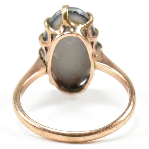 214 - A 9ct gold opal triplet ring. The ring set with an oval opal claw mounted opal triplet to tapering b... 