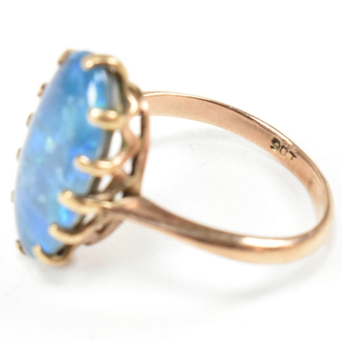 214 - A 9ct gold opal triplet ring. The ring set with an oval opal claw mounted opal triplet to tapering b... 