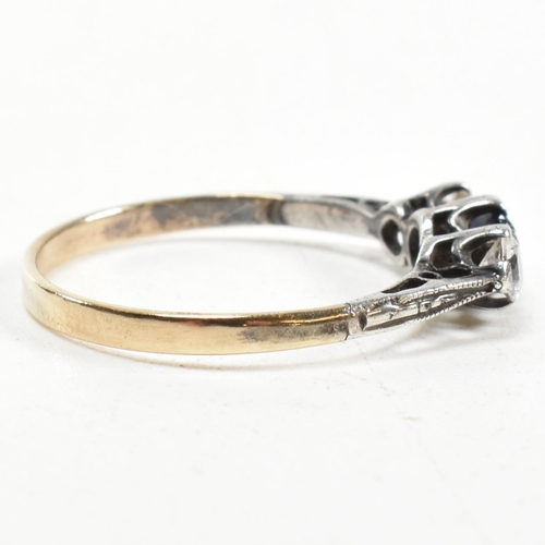 215 - A 9ct gold and silver spinel set three stone ring. The ring having an emerald cut spinet to centre w... 