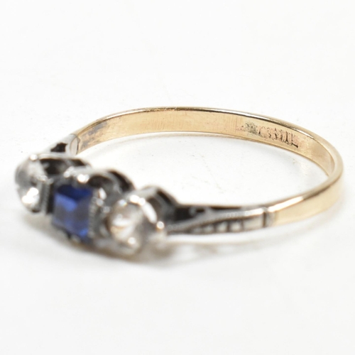 215 - A 9ct gold and silver spinel set three stone ring. The ring having an emerald cut spinet to centre w... 