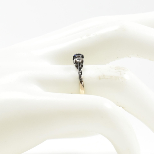 215 - A 9ct gold and silver spinel set three stone ring. The ring having an emerald cut spinet to centre w... 