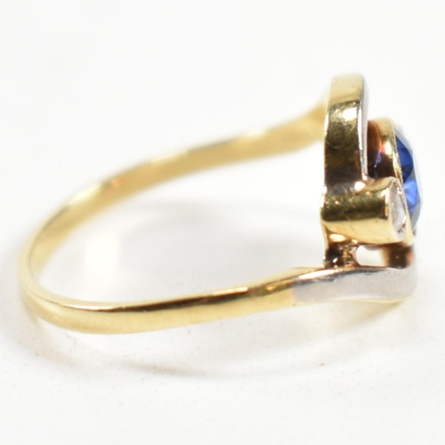 216 - An 18ct gold, sapphire and diamond cross over ring. The ring having a central bezel set sapphire wit... 