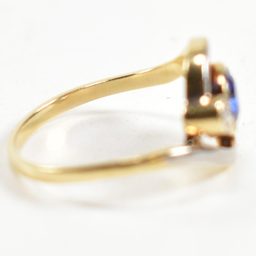 216 - An 18ct gold, sapphire and diamond cross over ring. The ring having a central bezel set sapphire wit... 