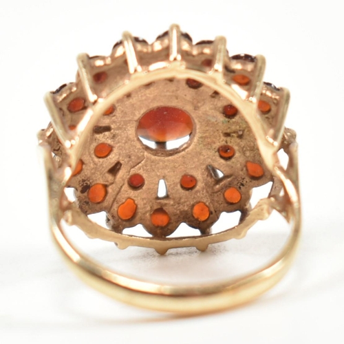 221 - A hallmarked 9ct gold and garnet cluster ring. The ring set with a central round cut garnet surround... 