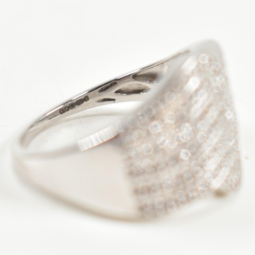 226 - A hallmarked 9ct white gold and diamond pave ring. The ring set with eight rows of pave set round cu... 