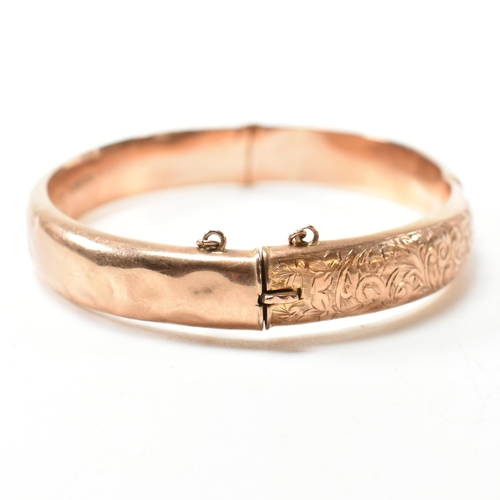 232 - An early 20th century hallmarked 9ct rose gold engraved hinged bangle. The 9ct rose gold bangle havi... 