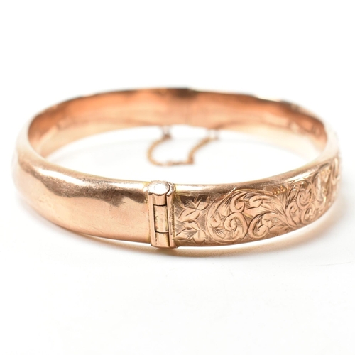 232 - An early 20th century hallmarked 9ct rose gold engraved hinged bangle. The 9ct rose gold bangle havi... 