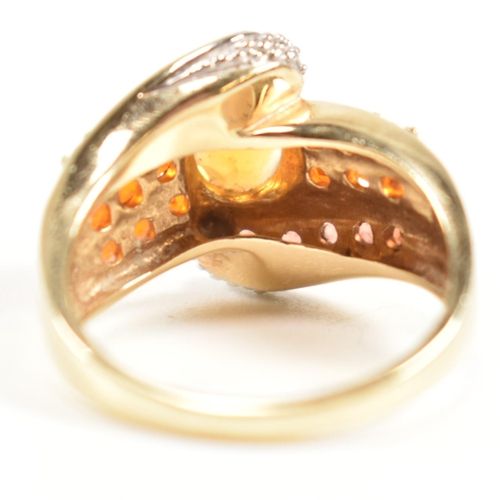 234 - A hallmarked diamond and gem set crossover ring. The ring having a central oval cut citrine set in a... 