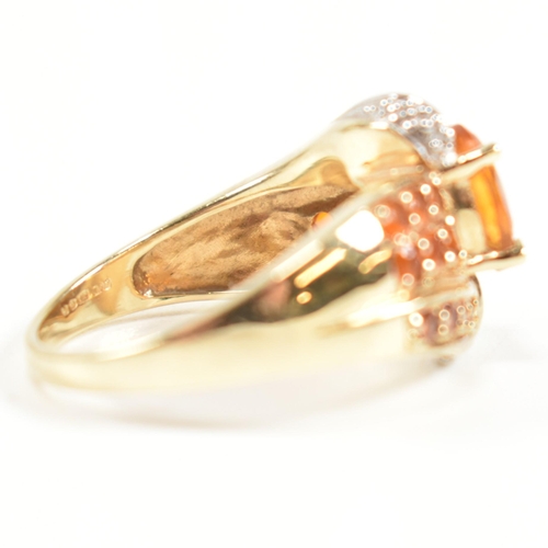 234 - A hallmarked diamond and gem set crossover ring. The ring having a central oval cut citrine set in a... 