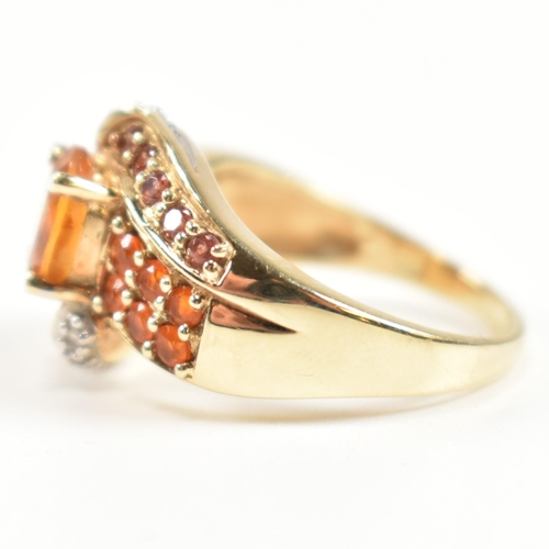 234 - A hallmarked diamond and gem set crossover ring. The ring having a central oval cut citrine set in a... 