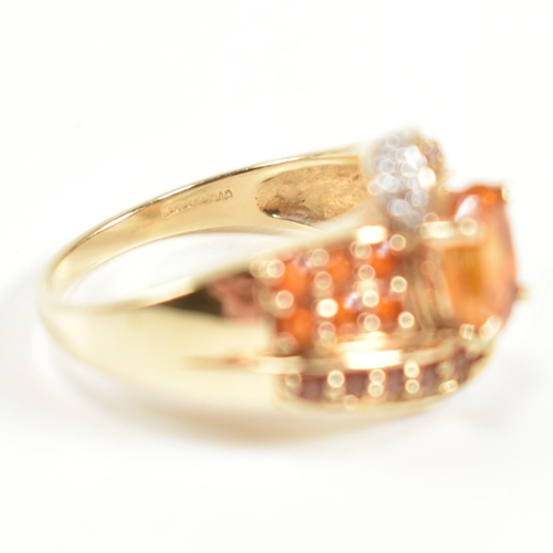 234 - A hallmarked diamond and gem set crossover ring. The ring having a central oval cut citrine set in a... 