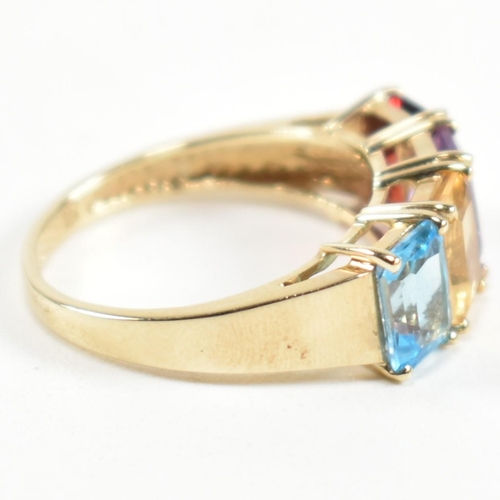 235 - A hallmarked 9ct gold, garnet, amethyst, citrine and topaz ring. The ring set with a row of emerald ... 