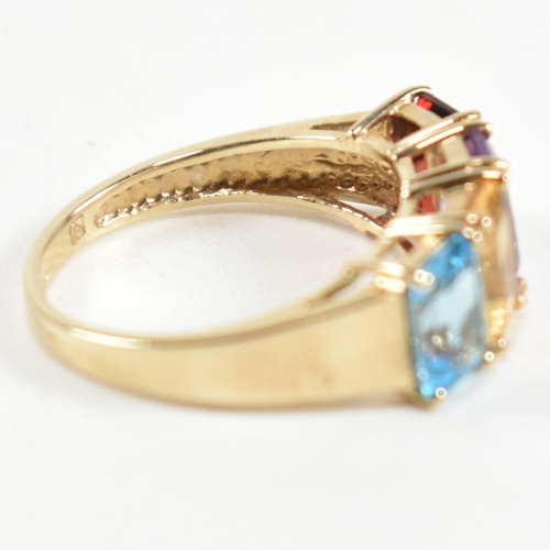 235 - A hallmarked 9ct gold, garnet, amethyst, citrine and topaz ring. The ring set with a row of emerald ... 