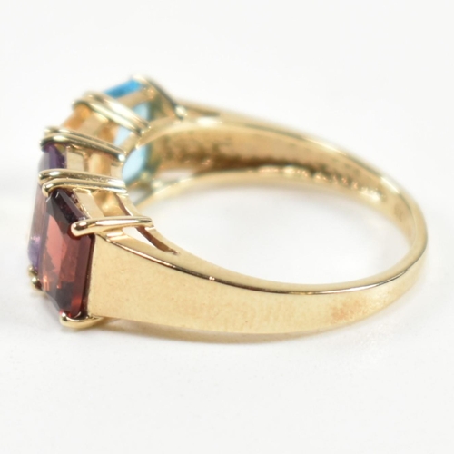 235 - A hallmarked 9ct gold, garnet, amethyst, citrine and topaz ring. The ring set with a row of emerald ... 