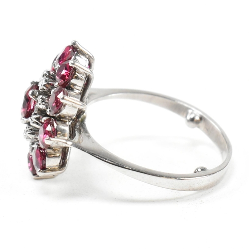 237 - A white gold ruby and diamond cluster ring. The ring set with round cut rubies and single cut diamon... 