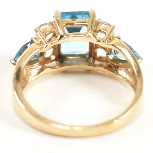 239 - A hallmarked 9ct gold, blue topaz and white topaz ring. The ring set with a central emerald cut blue... 