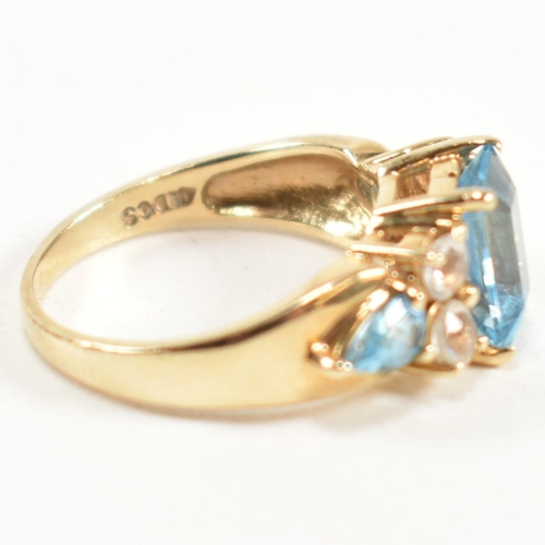 239 - A hallmarked 9ct gold, blue topaz and white topaz ring. The ring set with a central emerald cut blue... 