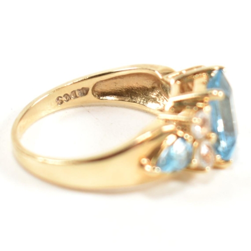 239 - A hallmarked 9ct gold, blue topaz and white topaz ring. The ring set with a central emerald cut blue... 